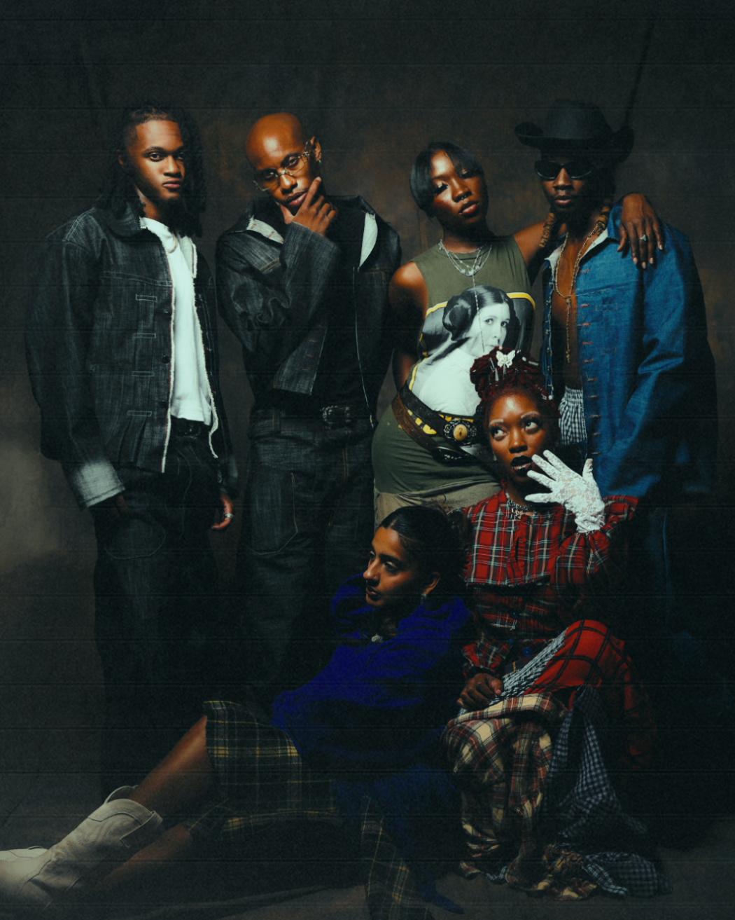 Group of people posing together against a dark background